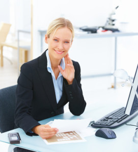 Portrait of a young smiling business woman sitting at office